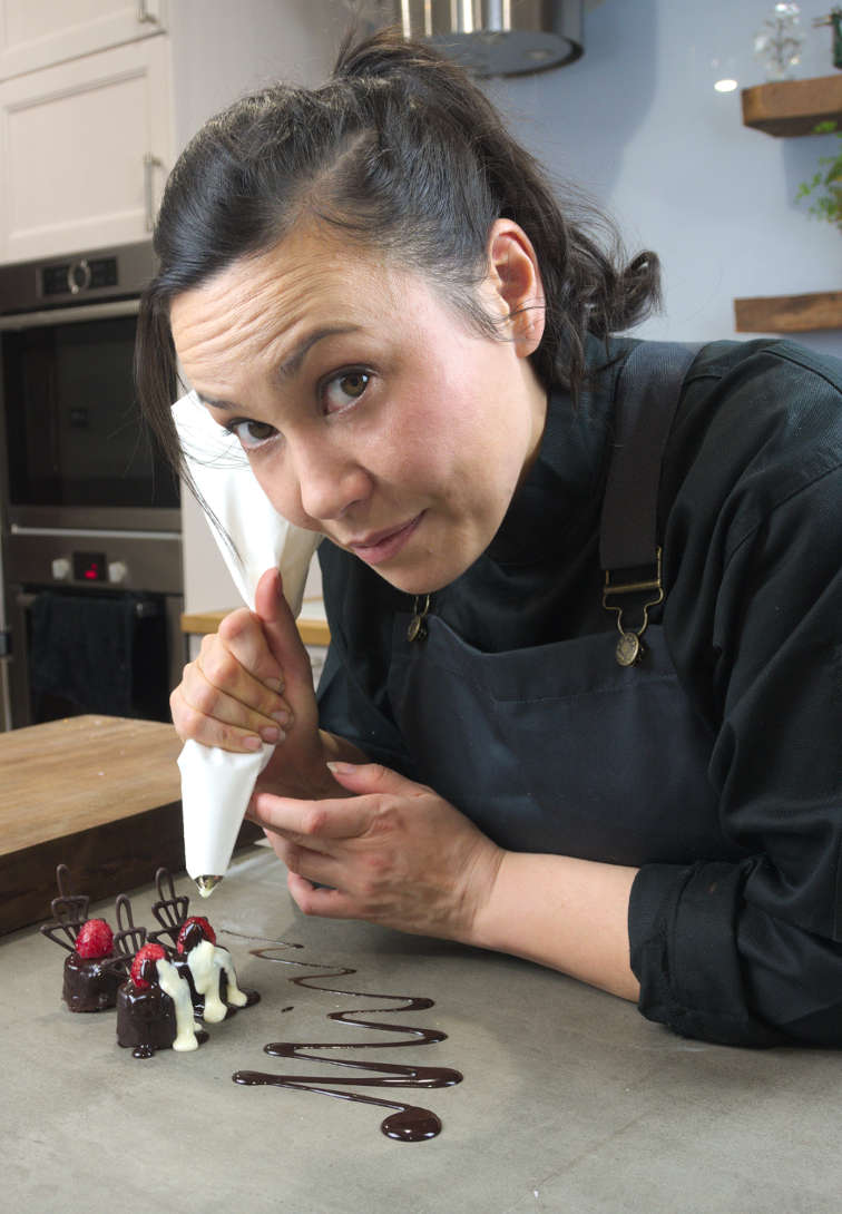 Terresia piping chocolate over a concrete bench-top